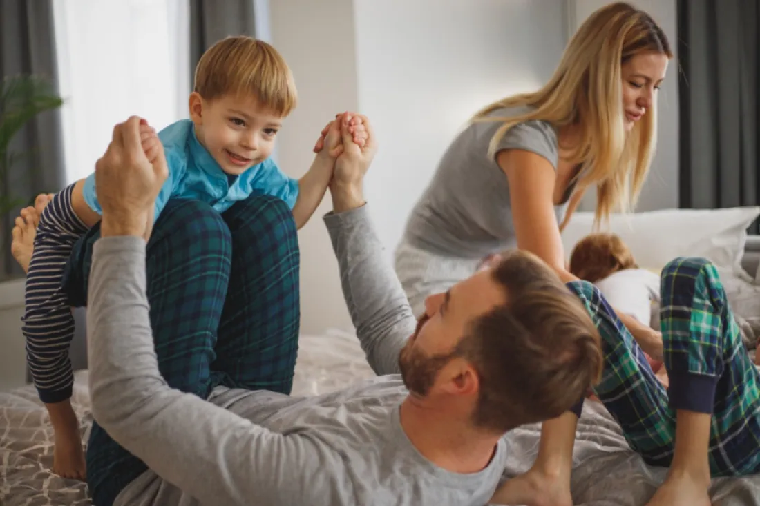Parents playing with their laughing son at home